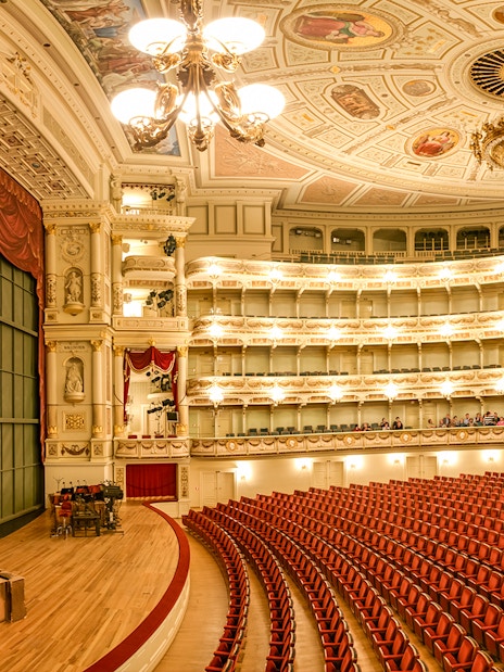 Semperoper Dresden auditorium with ornate ceiling and red seating.