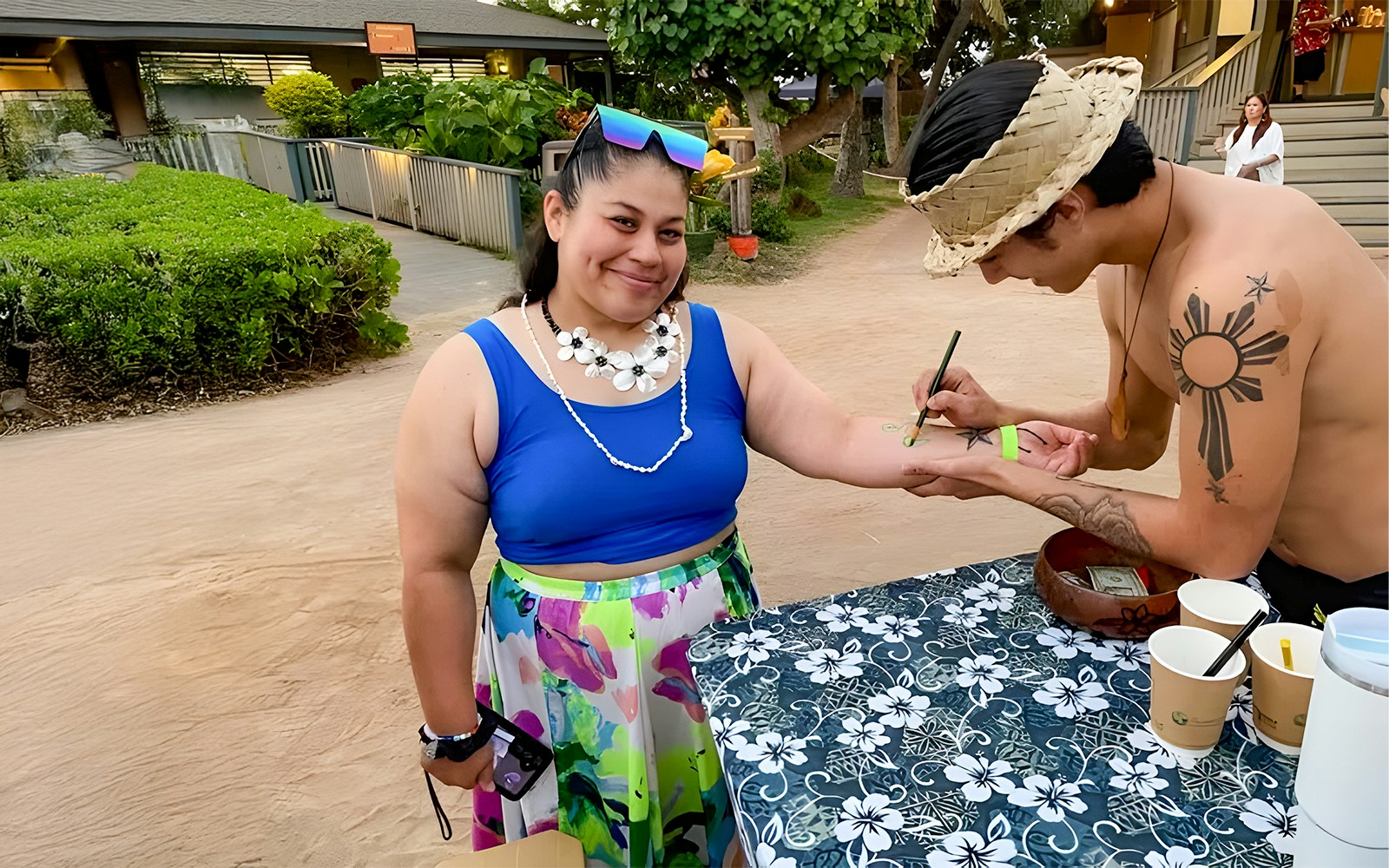 Guest receiving temporary tattoo at Germaine's Luau pre-show cultural activities.