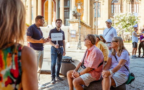 Tour guide leading a group at a historic site in Palermo, Italy, during a UNESCO walking tour.