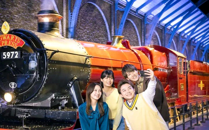 Group taking selfie in front of Hogwarts Express at Warner Bros. Studio Tour Tokyo.