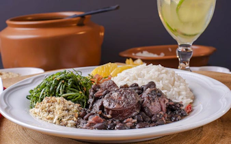 Authentic Brazilian feijoada with rice, greens, and orange slices in Rio de Janeiro.