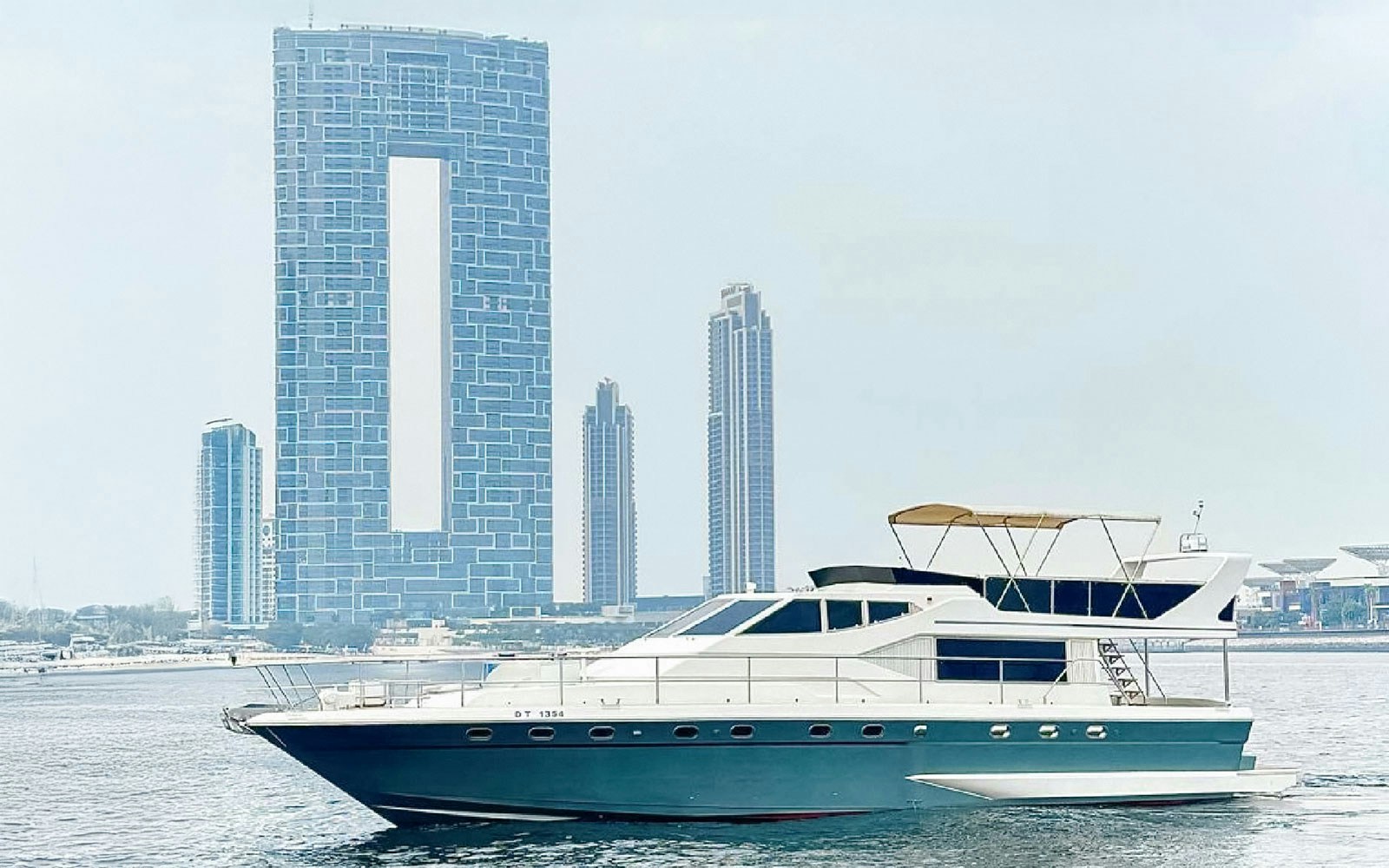 Luxury yacht cruising near Dubai Harbour with BBQ and snacks.