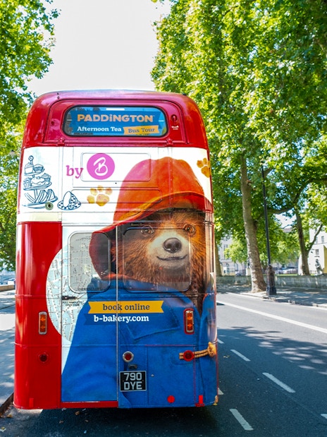 Red double-decker bus with Paddington Bear design for Brigit's Bakery Afternoon Tea tour in London.