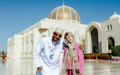 Tourists at Sultan Qaboos Grand Mosque, Muscat, during city highlights tour.