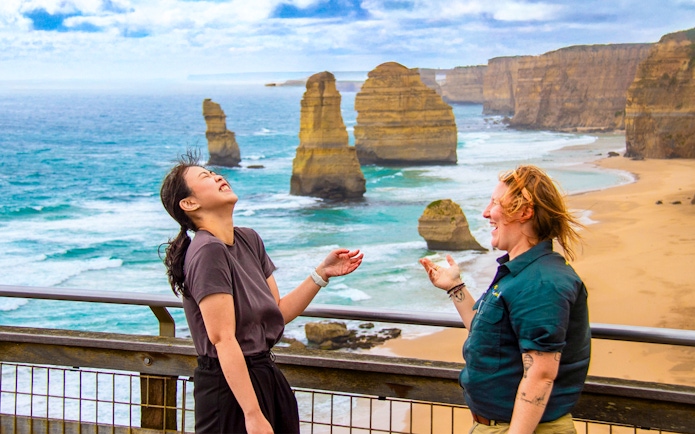 Tourists enjoying the view of the 12 Apostles on a Great Ocean Road guided tour.