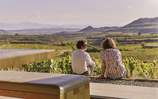 Couple enjoying vineyard view on Rioja wine tour from Bilbao.