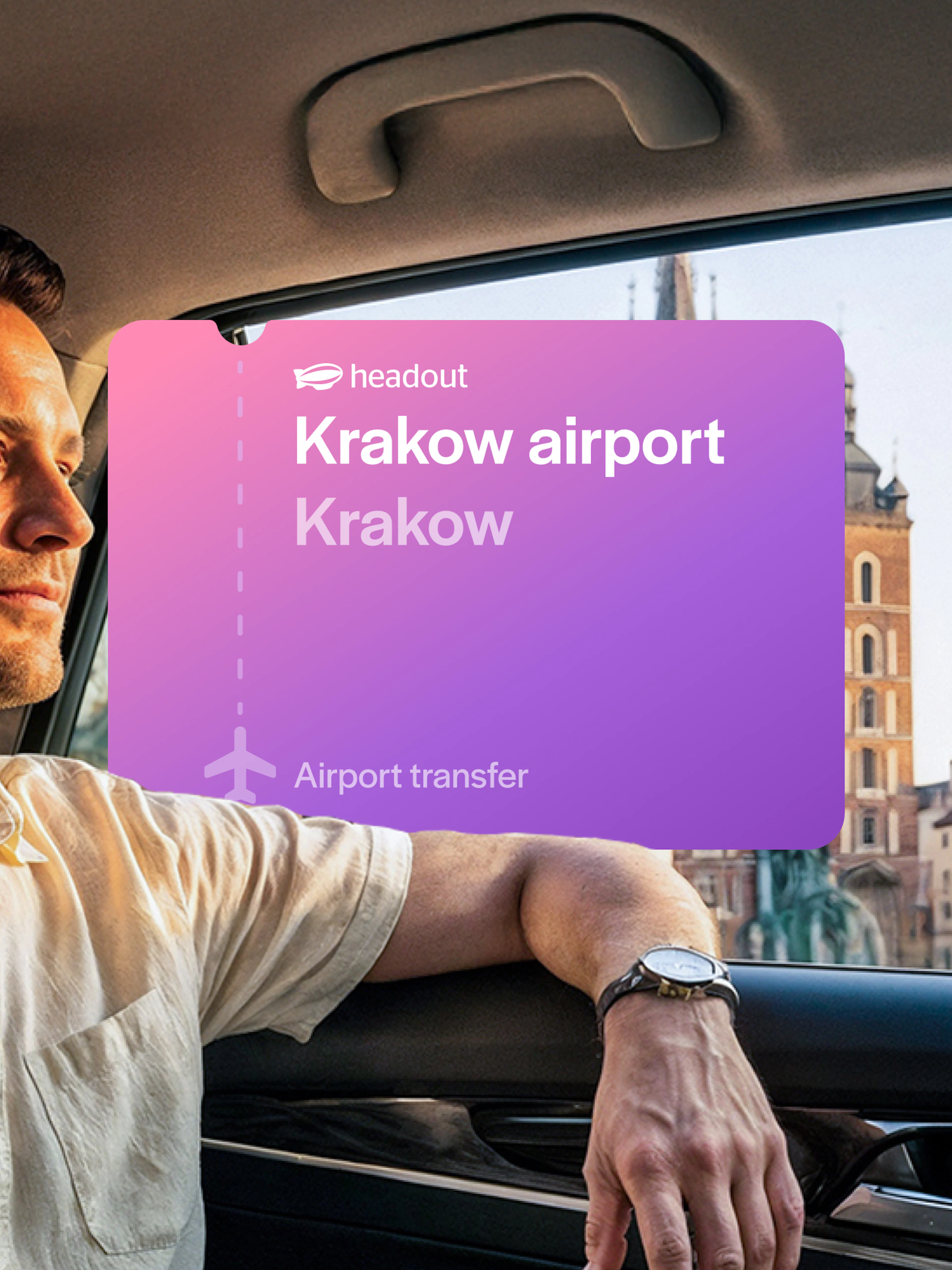 Man in car during Krakow airport transfer with city view in background.