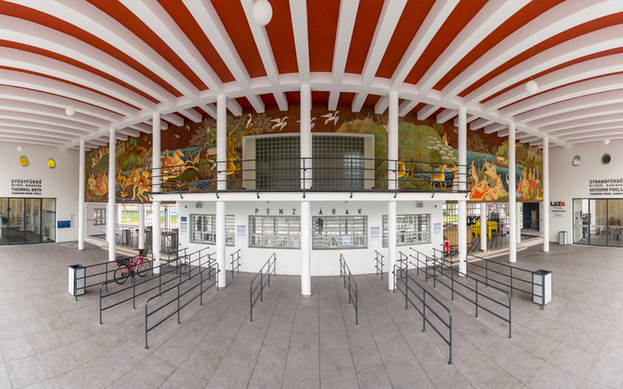 Entrance of Palatinus Spa Budapest with ticket counters and mural.