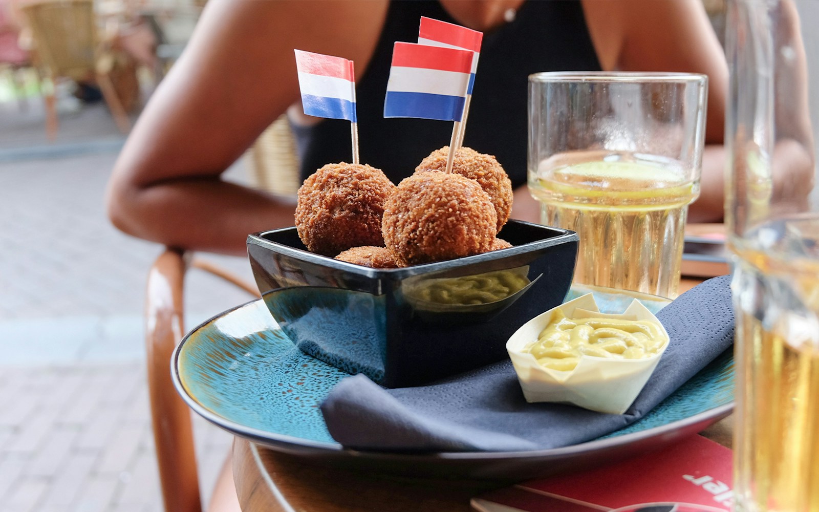 Bitterballen with mustard on a plate during a self-guided food tour in Amsterdam's Jordaan District.