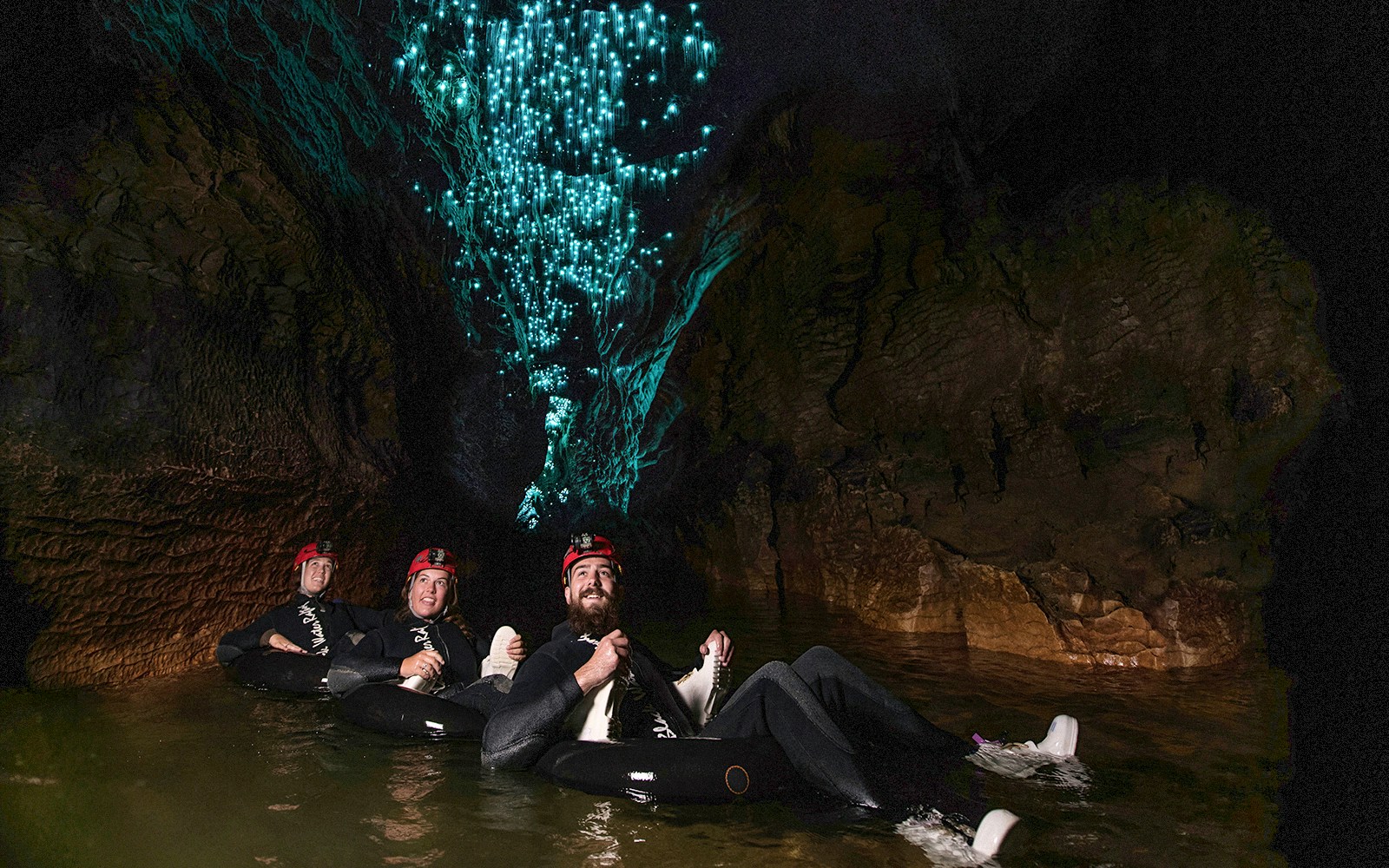 Guided black water rafting under glowworms in Waitomo cave.