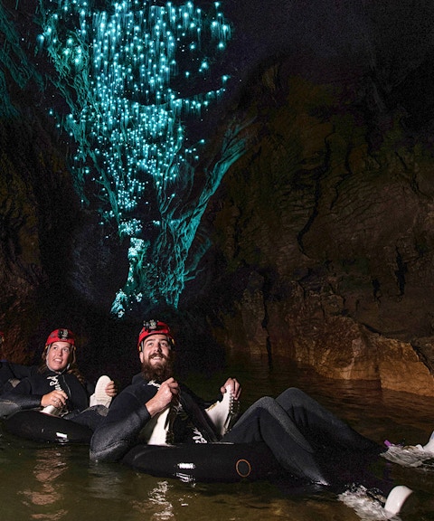 Guided black water rafting under glowworms in Waitomo cave.