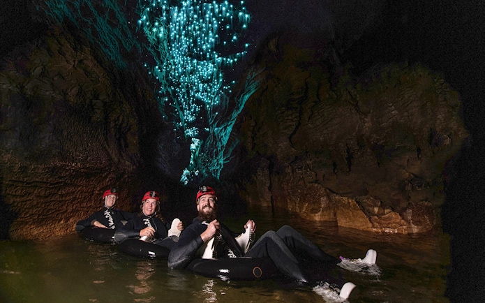 Guided black water rafting under glowworms in Waitomo cave.