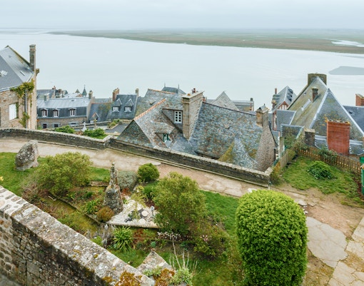 Rampart view of Mont Saint Michel with tourists exploring the historic site during a day trip.