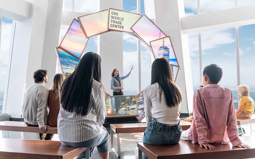 Visitors listening to a guide at One World Observatory, New York City.