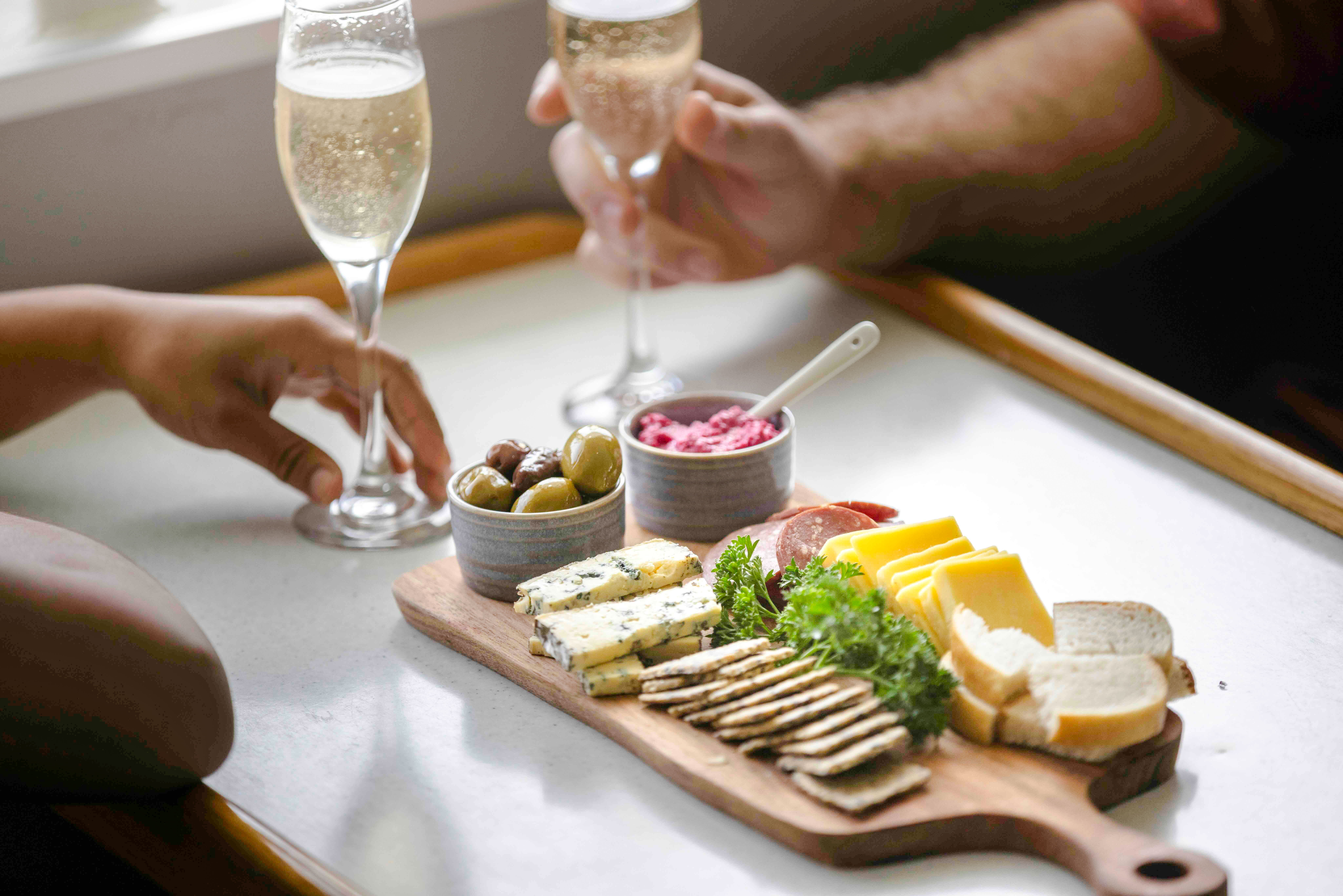 Champagne and charcuterie board with cheeses, meats, and olives on Doubtful Sound cruise.