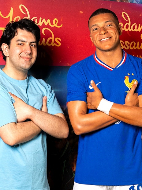 Wax figure of a football player at Madame Tussauds Berlin with two visitors.