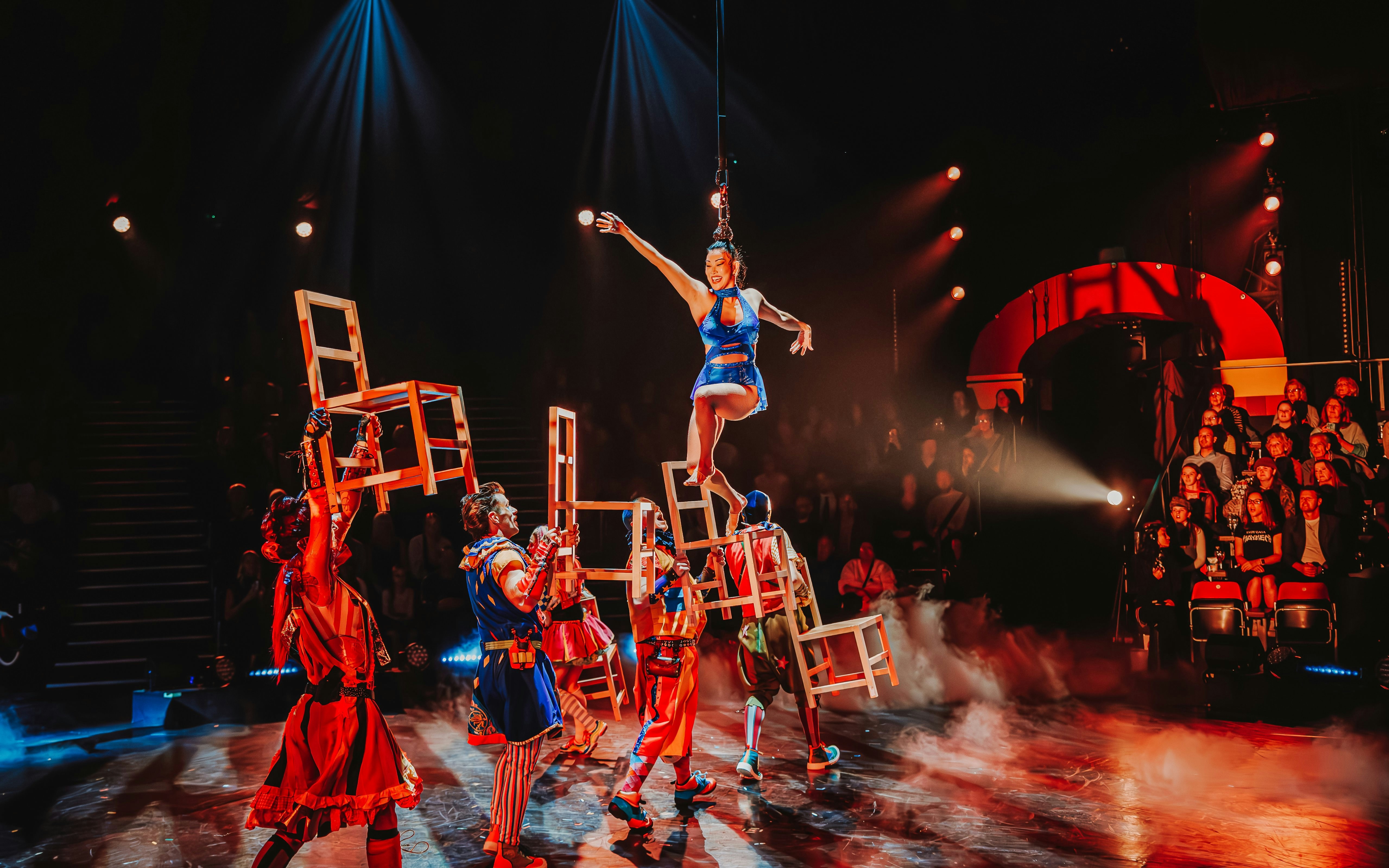 Performer balancing on chairs during Come Alive Westend stage show.