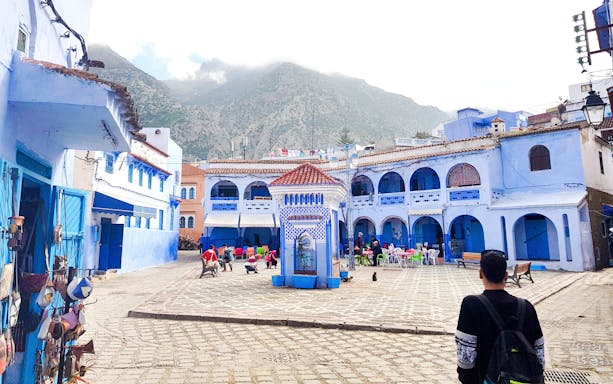 Chefchaouen Plaza with blue buildings and central fountain, Morocco.
