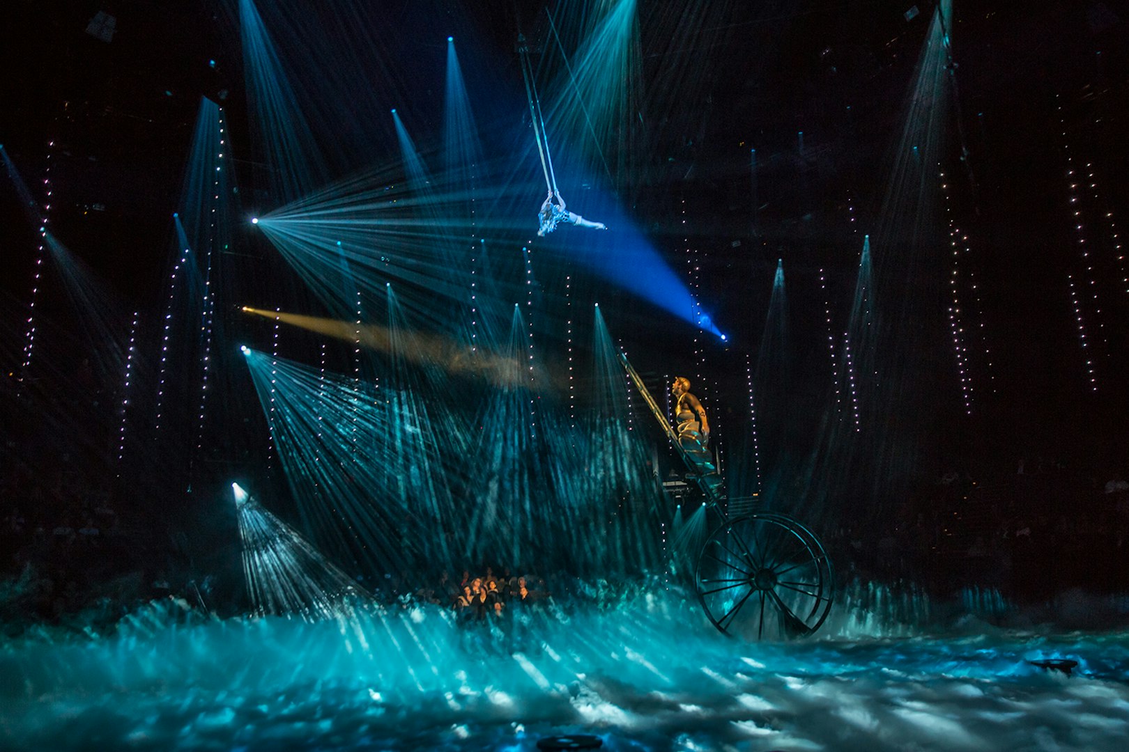 Acrobat performing above stage with blue lights at The Beatles LOVE show.