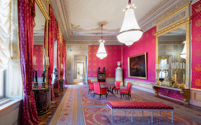 Habsburg State Rooms with ornate chandeliers, red drapes, and elegant furnishings.