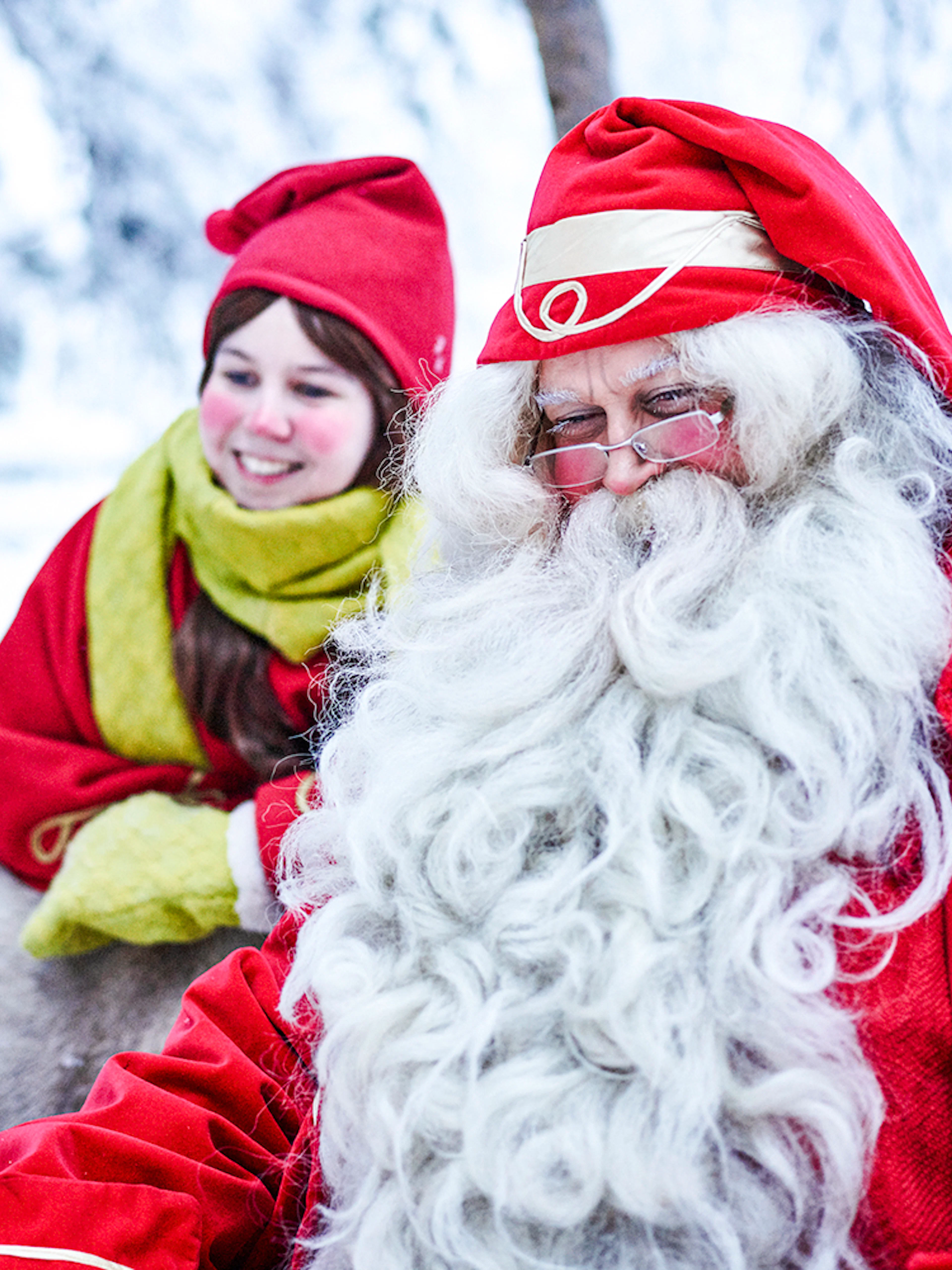 Santa Claus with a child in Santa Claus Village, Lapland, surrounded by snow.