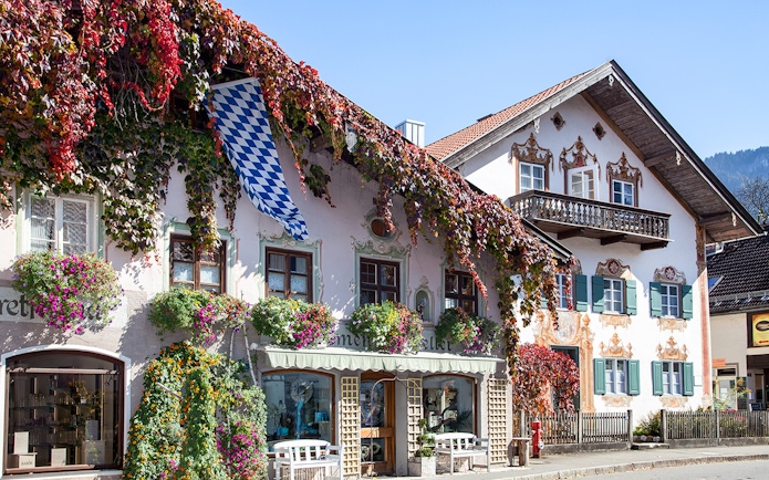 Bavarian house with painted facade and flowers in Oberammergau, Germany.