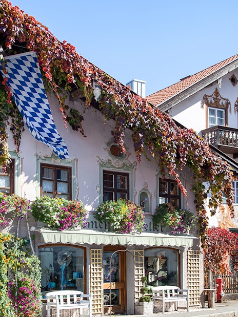 Bavarian house with painted facade and flowers in Oberammergau, Germany.