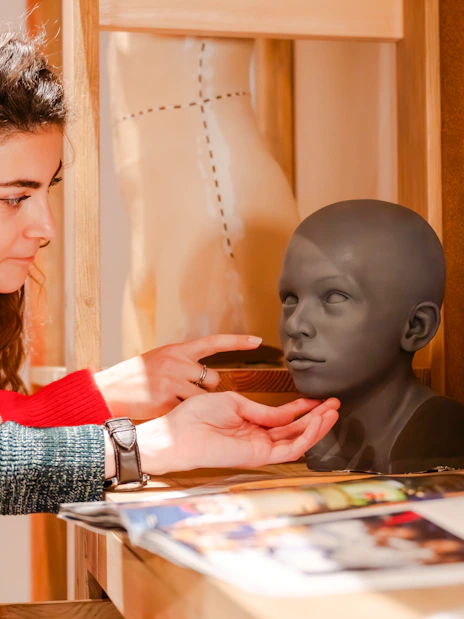 Visitors examining a wax head model at Grévin Paris Wax Museum.