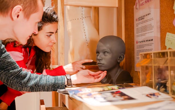 Visitors examining a wax head model at Grévin Paris Wax Museum.