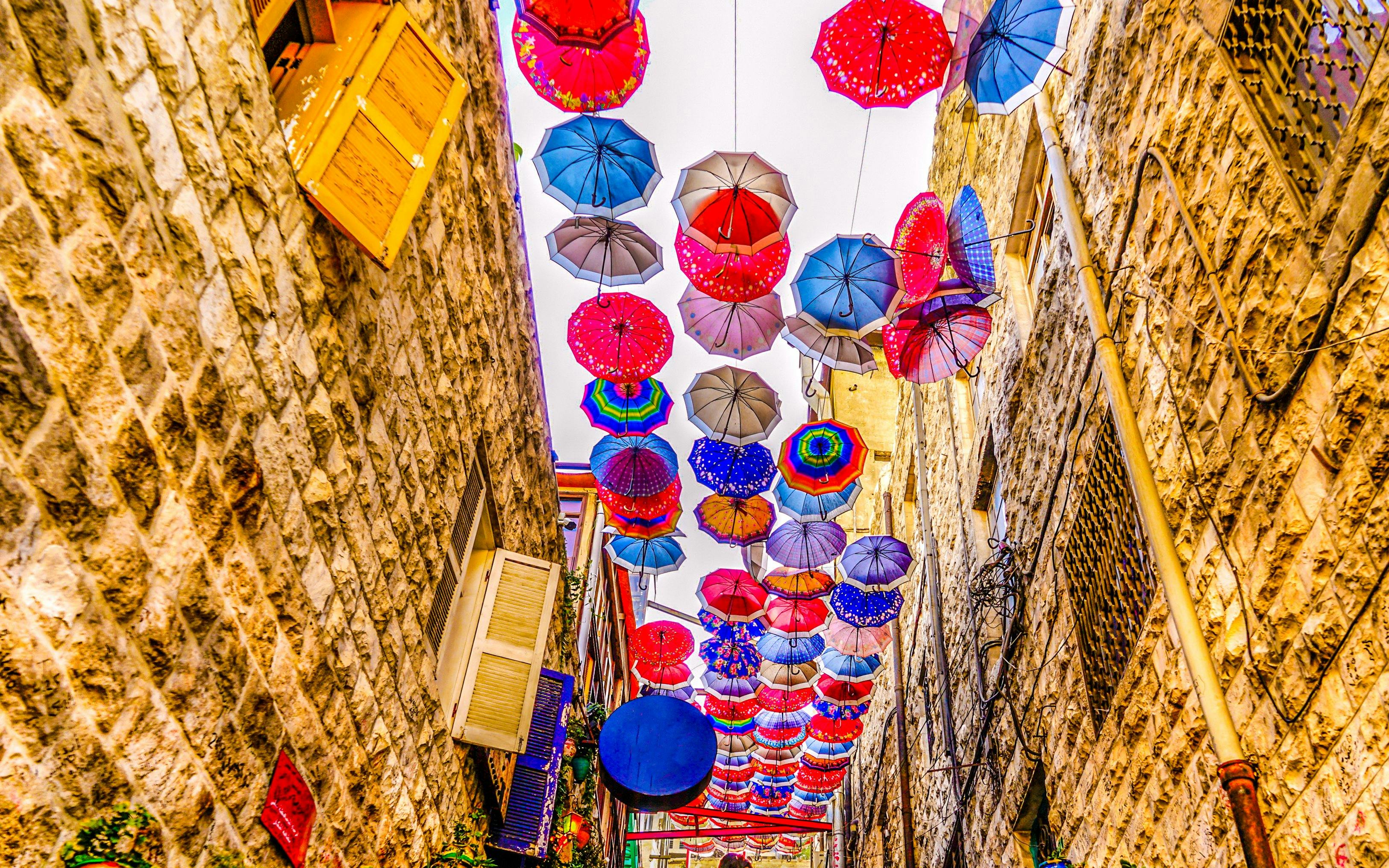 Colorful umbrellas hanging above an alley in old Amman, Jordan.