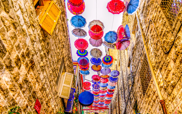 Colorful umbrellas hanging above an alley in old Amman, Jordan.