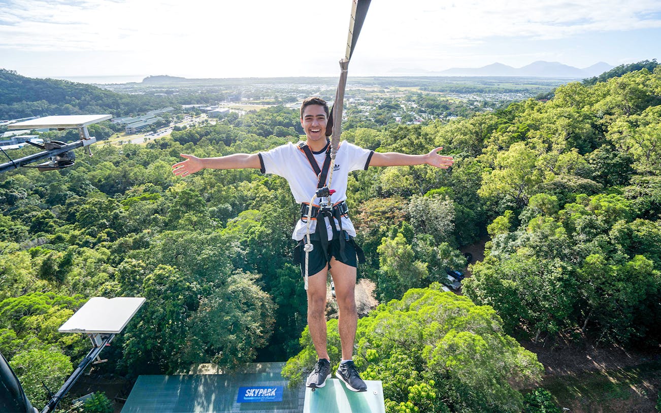 Participant harnessed on platform above forest at Walk The Plank by AJ Hackett, Cairns.