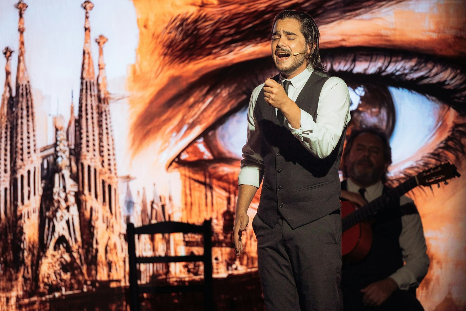 Musician performing at Teatro Flamenco Barcelona with Sagrada Familia backdrop.