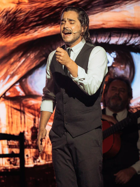 Musician performing at Teatro Flamenco Barcelona with Sagrada Familia backdrop.