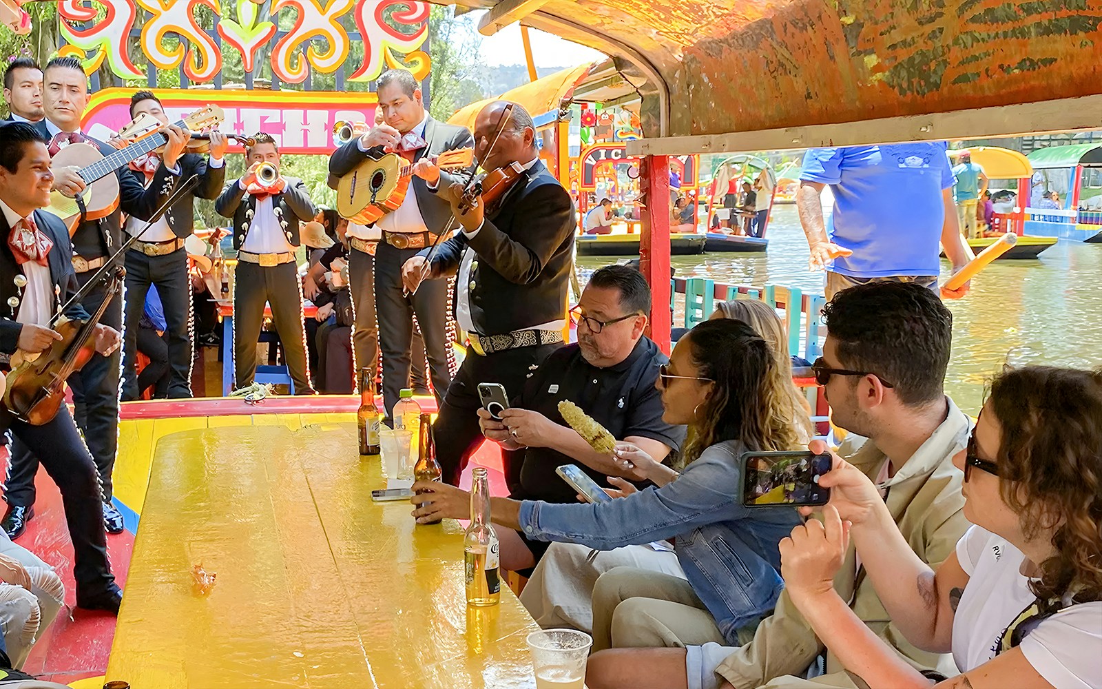 Guests enjoying mariachi band on Trajinera Party boat in Xochimilco, Mexico.