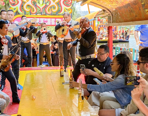 Guests on Trajinera Party boat enjoying live music in Xochimilco, Mexico City.