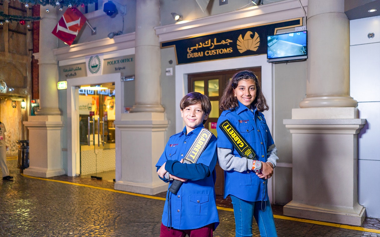Children in security uniforms at KidZania Dubai near Dubai Customs exhibit.