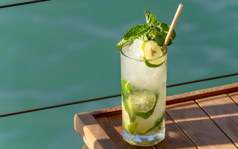 Refreshing cocktail on Yona Beach Club terrace, Phuket, overlooking the sea.