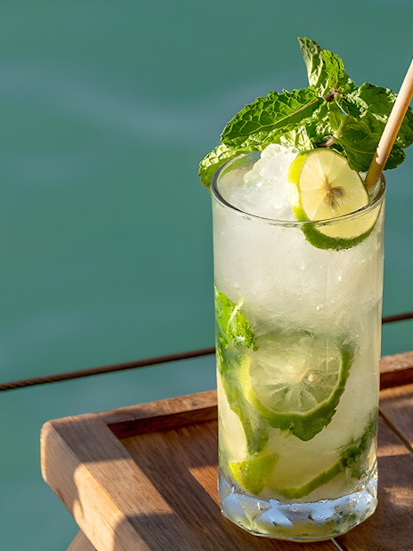 Refreshing cocktail on Yona Beach Club terrace, Phuket, overlooking the sea.