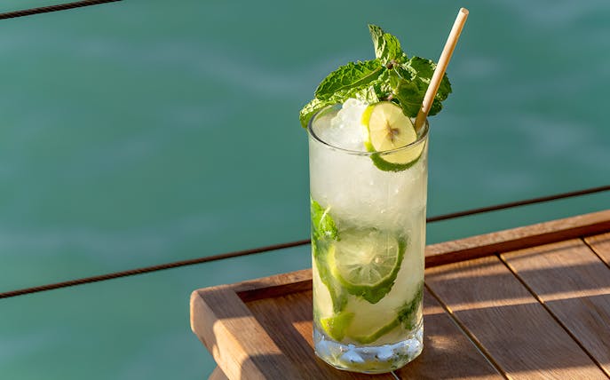 Refreshing cocktail on Yona Beach Club terrace, Phuket, overlooking the sea.