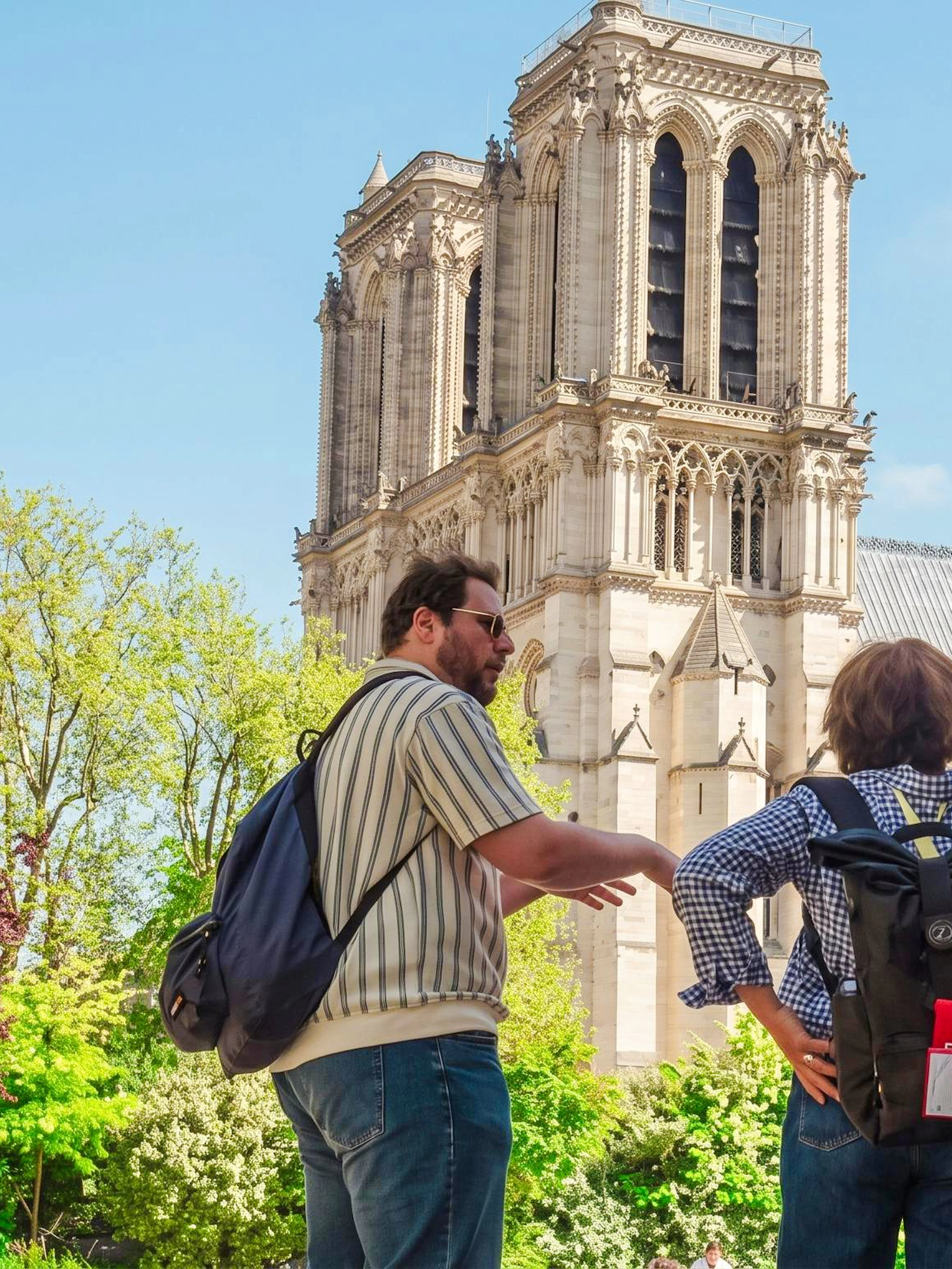 Tourists observing Notre-Dame Cathedral from Île de la Cité during a guided tour.