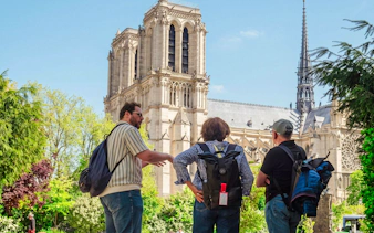 Tourists observing Notre-Dame Cathedral from Île de la Cité during a guided tour.