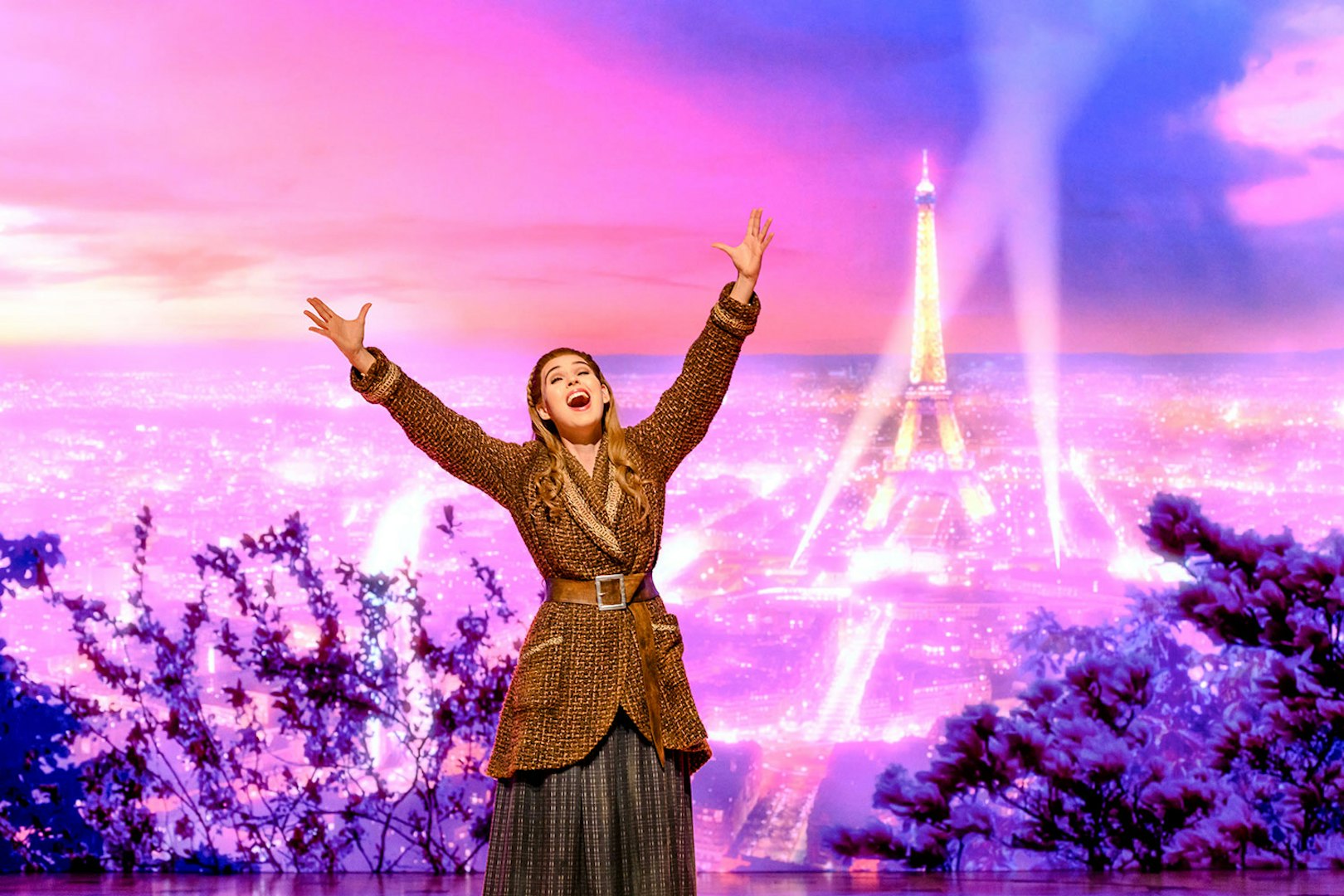 Performer on stage with Eiffel Tower backdrop in Anastasia theatre act.