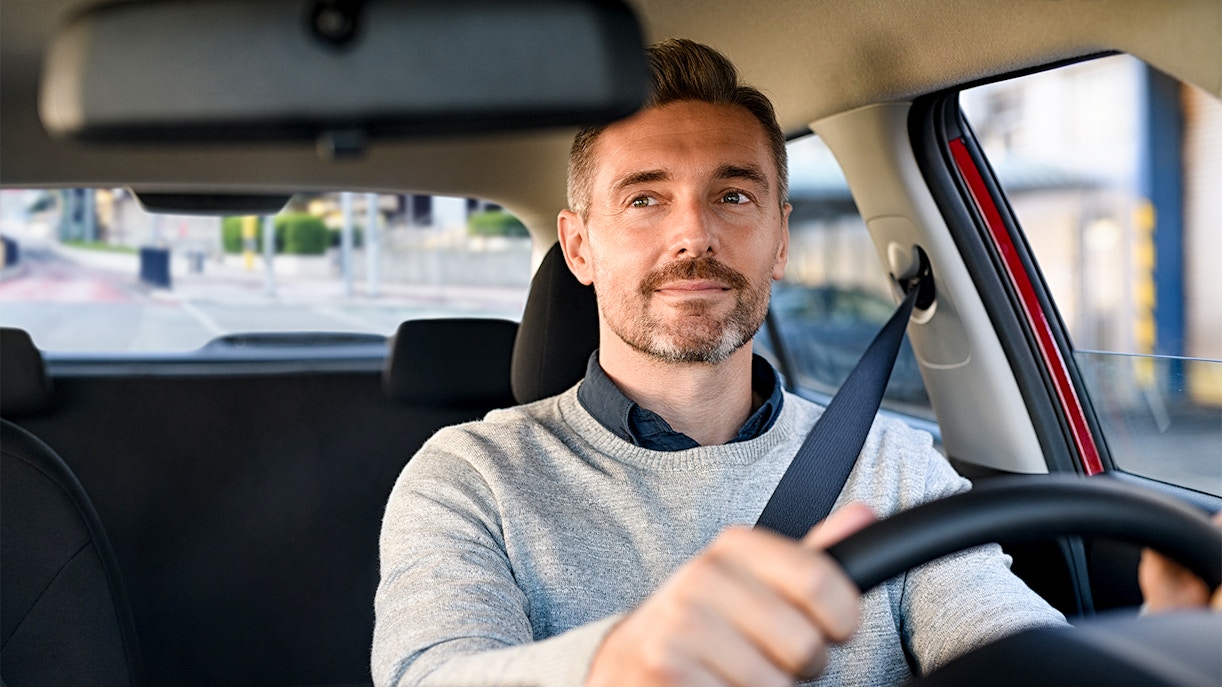 Man driving a car on a city street.