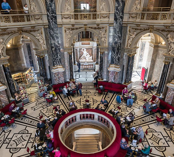 Kunsthistorisches Museum Vienna interior with visitors in ornate hall.