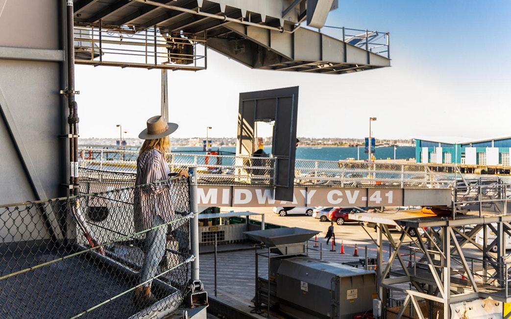 Visitor on USS Midway Museum deck overlooking San Diego Bay.