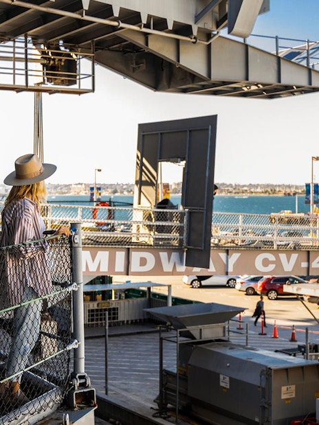 Visitor on USS Midway Museum deck overlooking San Diego Bay.