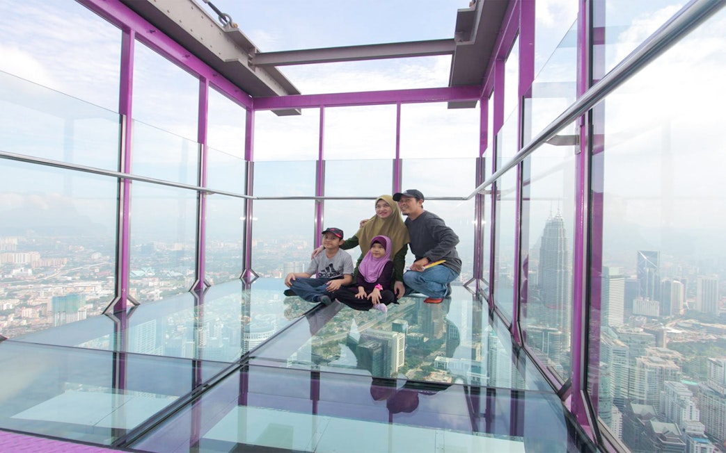 Family enjoying the view from KL Tower SkyBox in Kuala Lumpur.