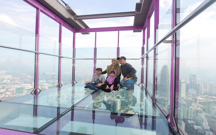 Family enjoying the view from KL Tower SkyBox in Kuala Lumpur.