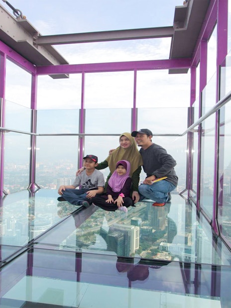 Family enjoying the view from KL Tower SkyBox in Kuala Lumpur.